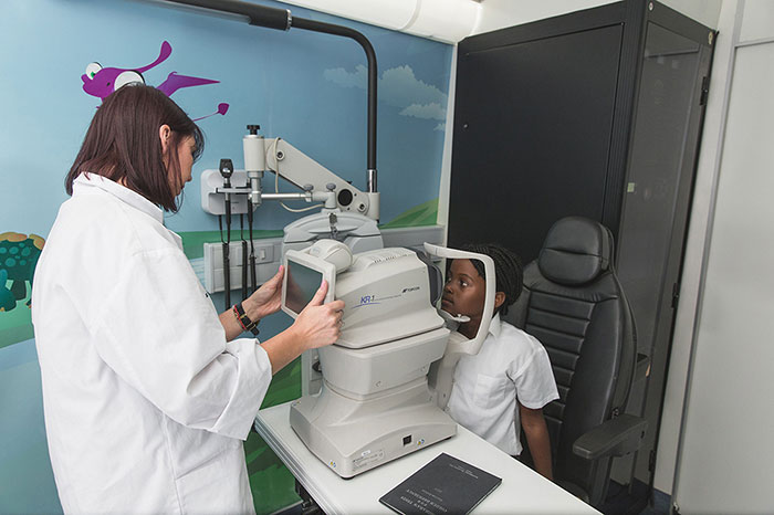 Kid having an eye test done on mobile clinic
